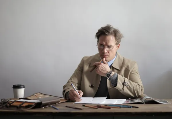 serious-businessman-taking-notes-in-documents-duri