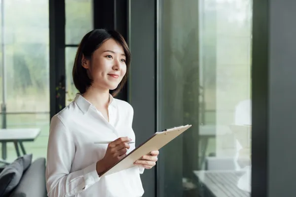 An Asian business woman with short hair is working