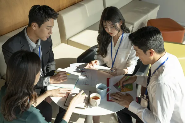 A team of office workers is having a meeting to di